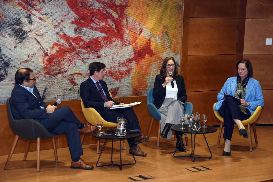 El evento abordó el sector de las TI y el vínculo entre Uruguay y Estados Unidos Ministra Facio habla con un micrófono, sentada; a sus lados, moderador y expositores