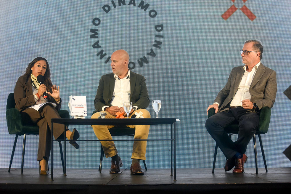 Cardona habla, sentada, junto a Legnani y Gili; detrás, pantalla con el nombre del evento