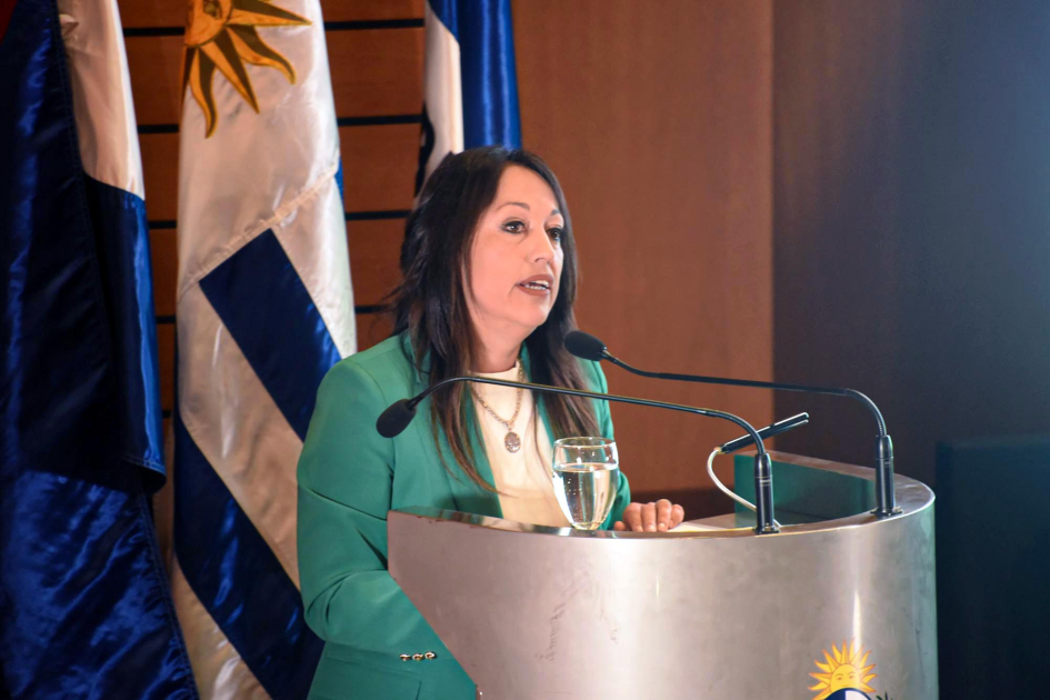 Ministra Fernanda Cardona Cardona habla desde un atril; detrás, banderas