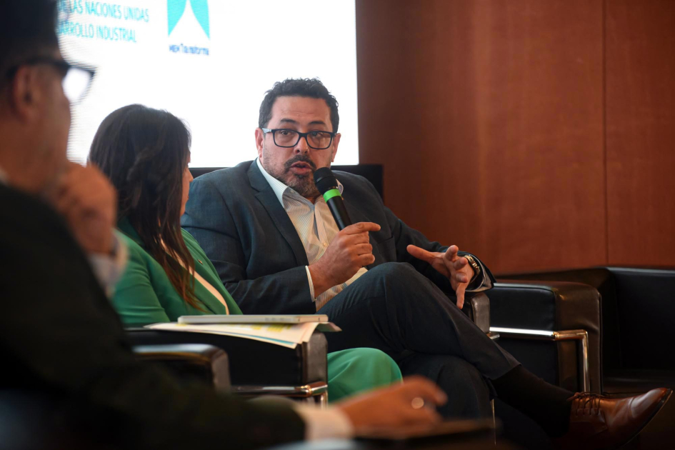 Prosecretario de la Presidencia de la República, Alejandro Sánchez Sánchez dialoga con expositoras y expositores; detrás, pantalla