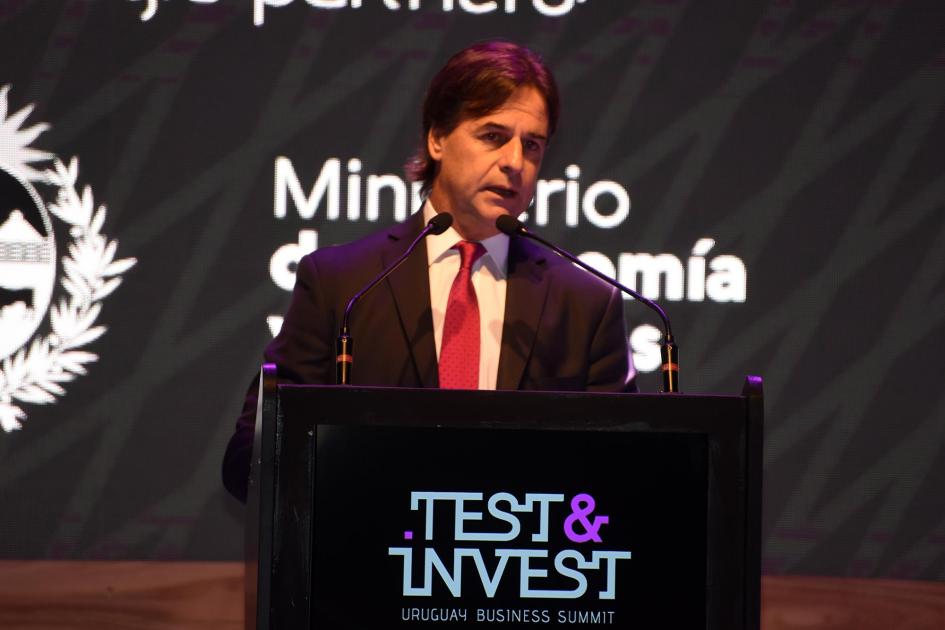 Presidente Luis Lacalle habla en un atril con el logo de Test & Invest