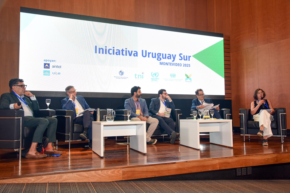 Panel 3 de la primera jornada del encuentro Moderador y cinco panelistas, sentados; detrás, pantalla
