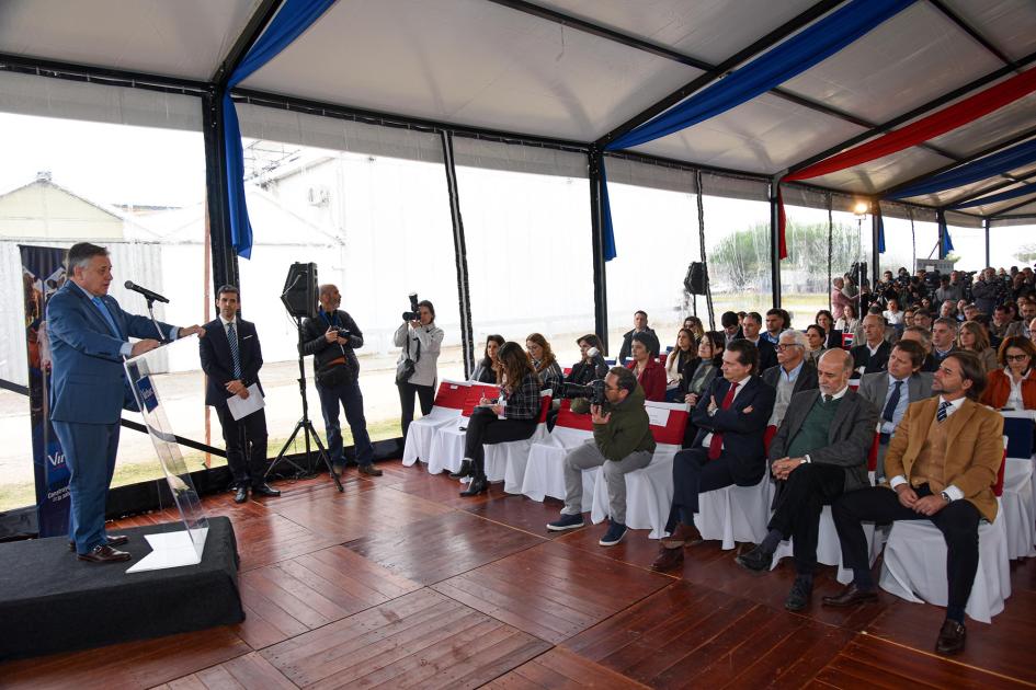 Presentación del ministro Omar Paganini Paganini, a la izquierda, habla desde un atril; a la derecha se ve el público; están en una carpa