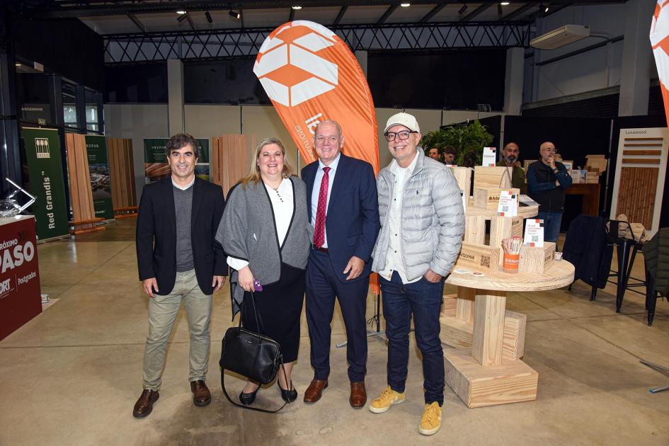 El subsecretario Walter Verri con participantes y organizadores Verri posa con otras personas en el salón del evento; detrás, elementos de empresas participantes