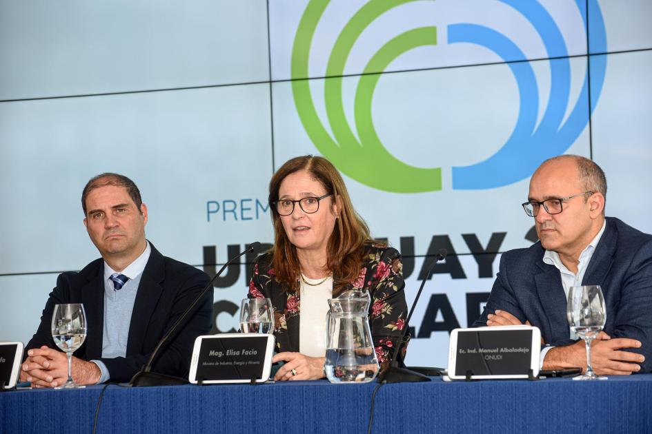 Ministra Facio, junto a Caiafa y Albaladejo; detrás, pantalla con el logo del premio