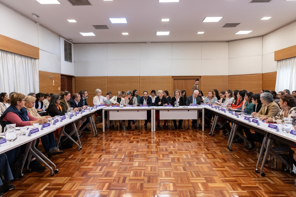 Personas sentadas en mesa en forma de "u"
