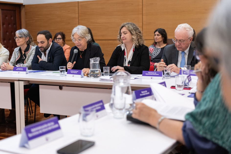 Personas sentadas en mesa en forma de "u"; habla la directora Xavier