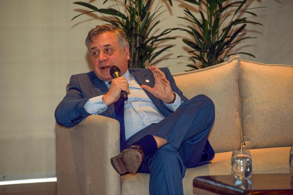 Ministro Omar Paganini Paganini, sentado en un sillón; detrás hay plantas