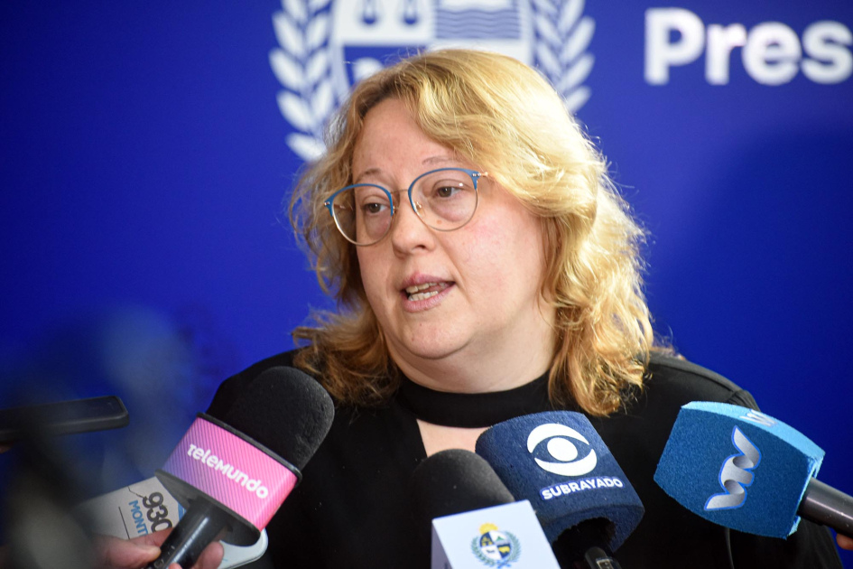 Directora Nacional de Artesanías, Pequeñas y Medianas Empresas, Ximena Cidrás Cidrás habla, frente a micrófonos; detrás, banner de Presidencia