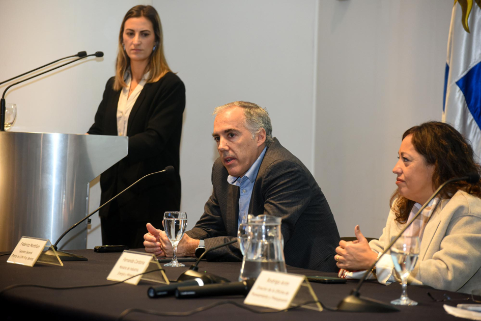 Lanzamiento del Programa de Desarrollo de Proveedores Nacionales de UPM 2026: mesa de autoridades Mantiñan habla junto a Cardona; al lado, maestra de ceremonias, de pie