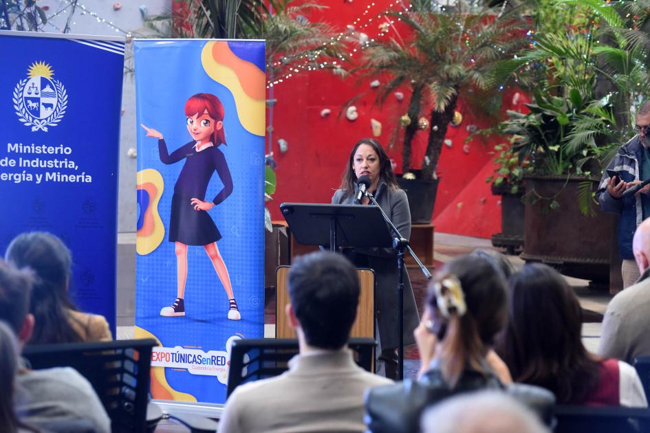 La ministra Fernanda Cardona remarcó la importancia de este concurso Ministra habla en un atril; al lado, banners; más cerca, está el público sentado y de espaldas