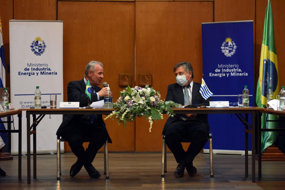 Ministros Bento de Albuquerque y Omar Paganini Habla De Albuquerque, junto a Paganini; detrás, la bandera de Brasil y banners del MIEM