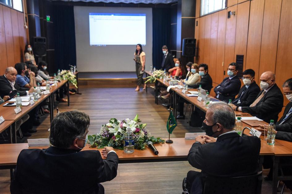 Vista de la mesa de trabajo desde detrás de los ministros (la cabecera); al fondo hay una pantalla