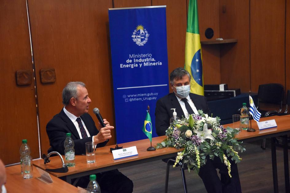 Ministro Bento de Albuquerque manifestó su satisfacción con el diálogo Ministro De Albuquerque habla junto a Paganini; detrás, un banner del MIEM y una bandera de Brasil