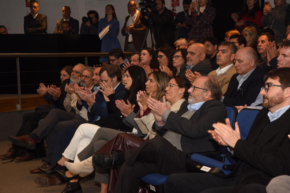 Participantes aplauden, sentados; en primera fila, autoridades