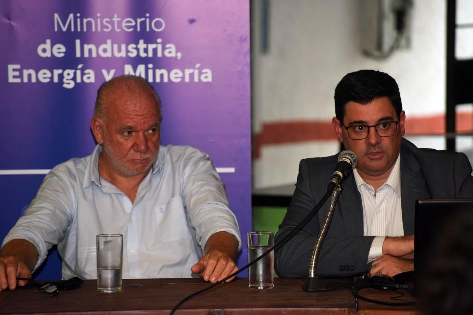 Director nacional de Energía, Fitzgerald Cantero Habla el director Cantero junto al subsecretario Verri, sentados en una mesa; detrás, banner de MIEM