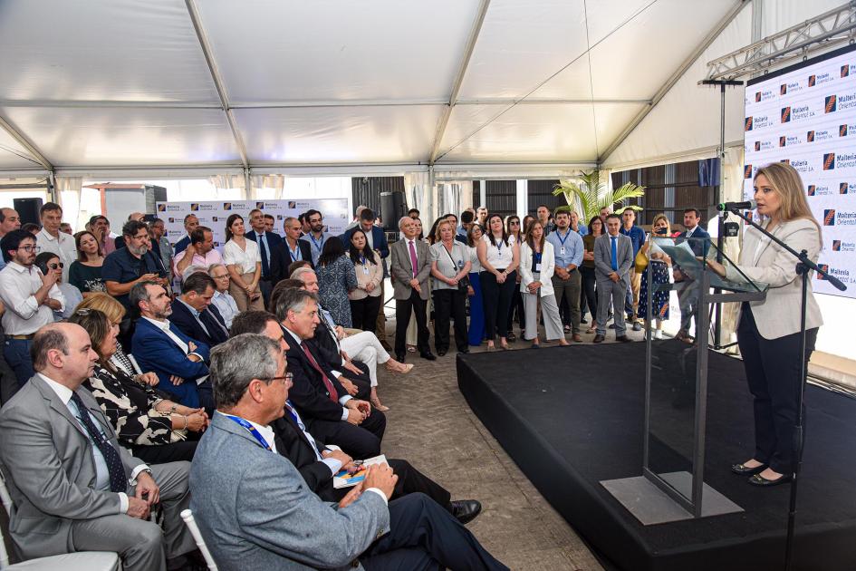La directora Susana Pecoy cerró la parte oratoria Directora Pecoy habla desde un atril ante el público; detrás hay una pantalla con el logo de MOSA