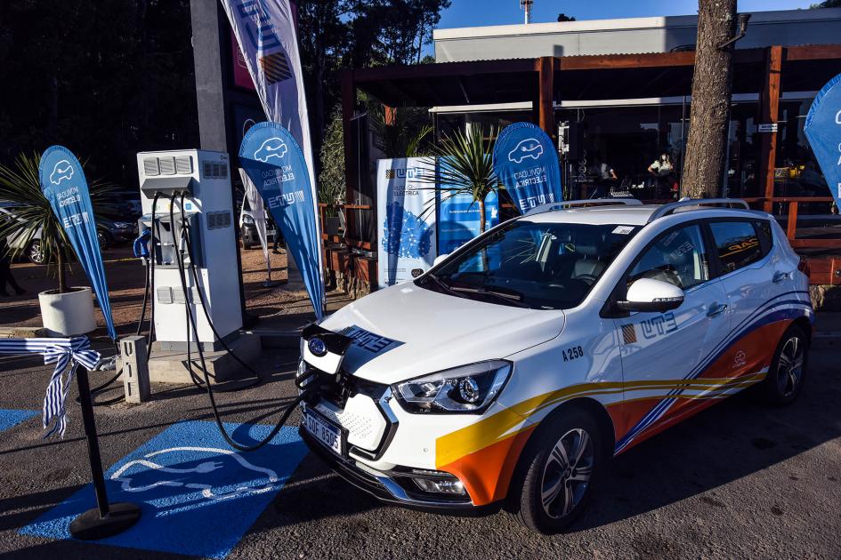 Vehículo conectado a punto de carga Automóvil conectado a punto de carga; detrás, banners celestes de UTE