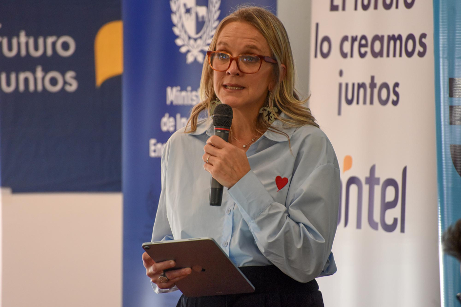 Erika Hoffmann, presidenta del Secan Hoffmann habla; detrás, banners de Antel y el MIEM