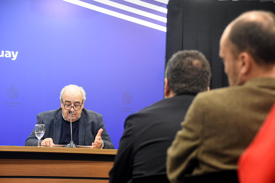 Ministro Alfredo Fratti Fratti habla; detrás, banner azul; más cerca, público, de espaldas