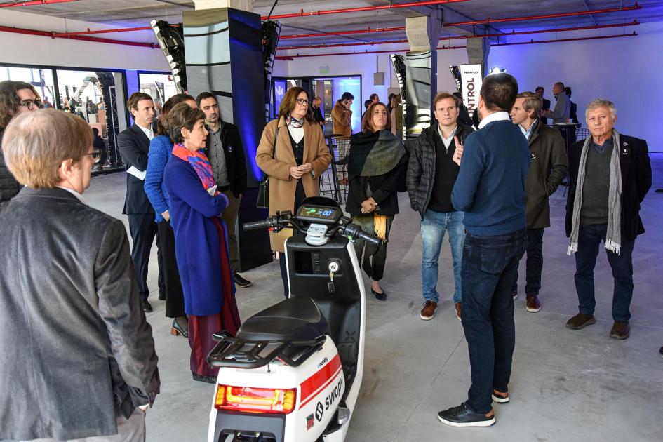 La ministra conoció los proyectos de las startups MInistra y otras personas atienden una charla frente a una moto