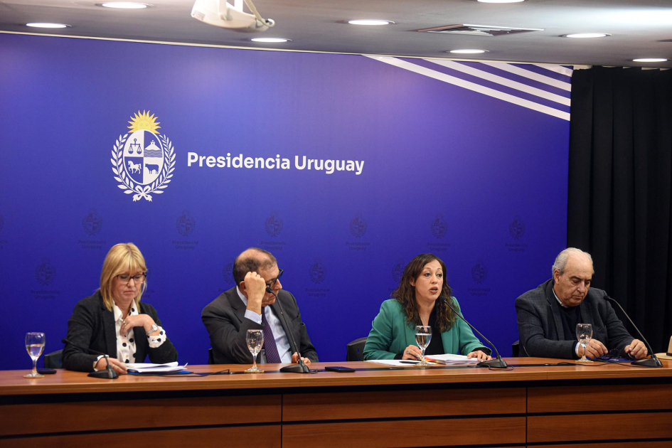 Presentación del proyecto de ley de competitividad y reducción de costo de vida Cardona habla junto a Oddone, Fratti y Lustemberg; detrás, banner de Presidencia