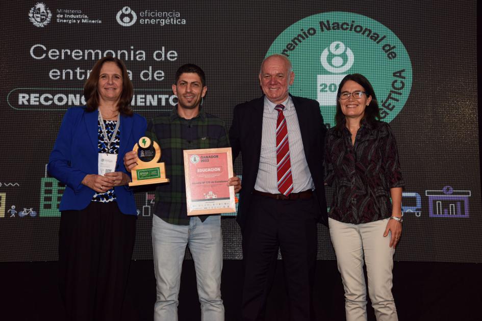 Representantes de la escuela n.º 170 de Canelones Una mujer, un hombre, Facio y Verri; detrás, una pantalla