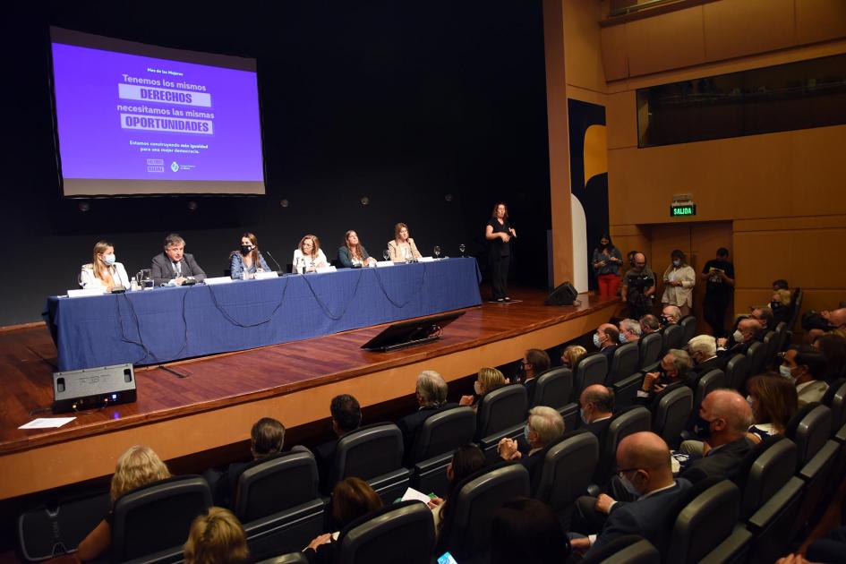 Evento; en el fondo se ve la placa con el lema del Día de la Mujer 2022