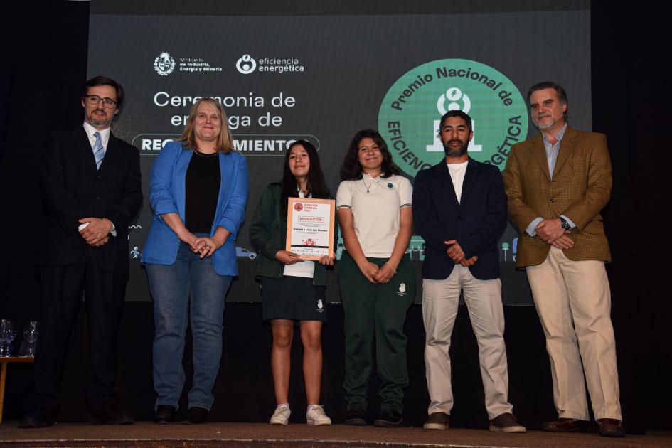 Representantes del Colegio y liceo Los Rosales Tres hombres, una mujer y dos adolescentes de género femenino, que reciben la placa