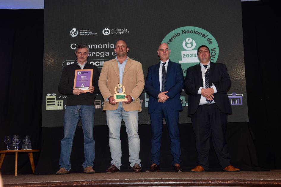 Representantes de MCT Ingeniería Cuatro hombres; uno sostiene la placa; otro, el premio