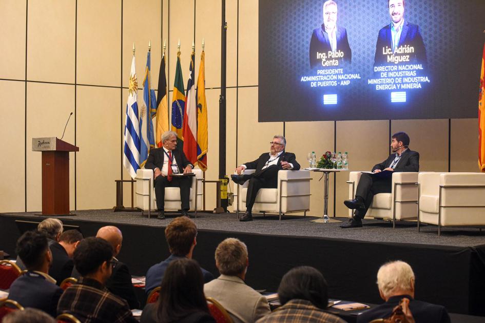 Público sentado de espaldas; al fondo, autoridades del evento. 
