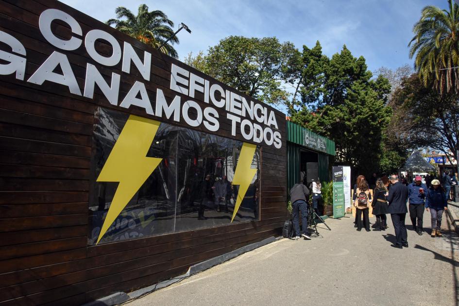Stand de Eficiencia Energética Fachada del stand de Eficiencia Energética; cartel dice "Con eficiencia ganamos todos"; hay rayos