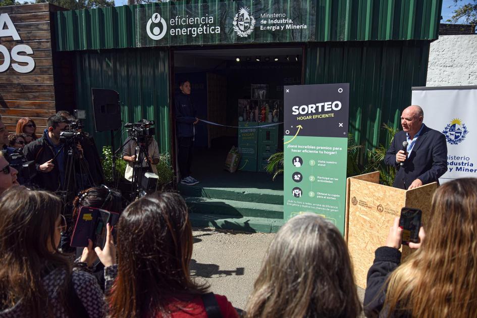 El ministro interino dio la bienvenida en el stand de Eficiencia Energética Verri habla desde un atril de madera; de espalda, público