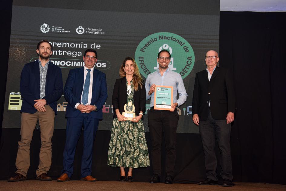 Representantes de Montevideo Refrescos Cantero, tres hombres (uno sostiene la placa) y una mujer (que sostiene el premio)