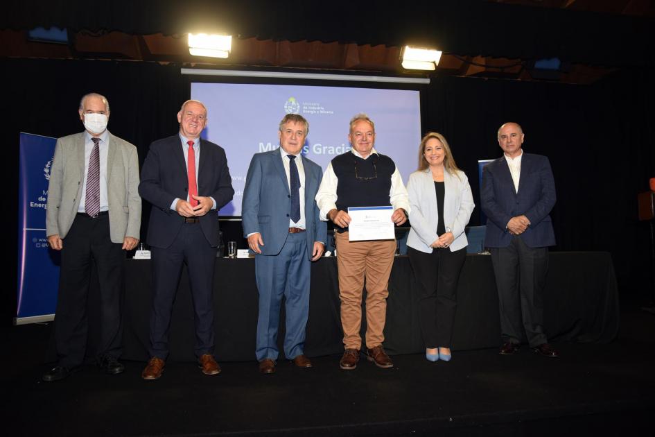 Certificado para Metalúrgica Viscazo SRL Un hombre muestra su certificado junto a las autoridades; detrás, una pantalla azul
