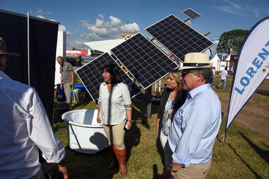 Ministro Paganini y directora Pecoy junto a paneles solares y otras personas