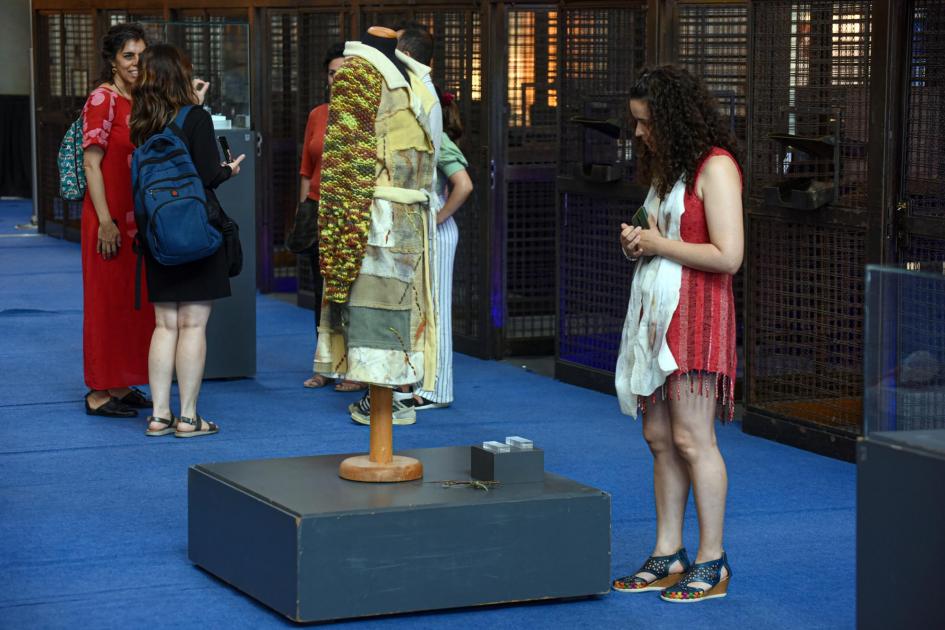Otra de las piezas seleccionadas Mujeres ven las piezas; una de ellas se detiene en un vestido de tejido