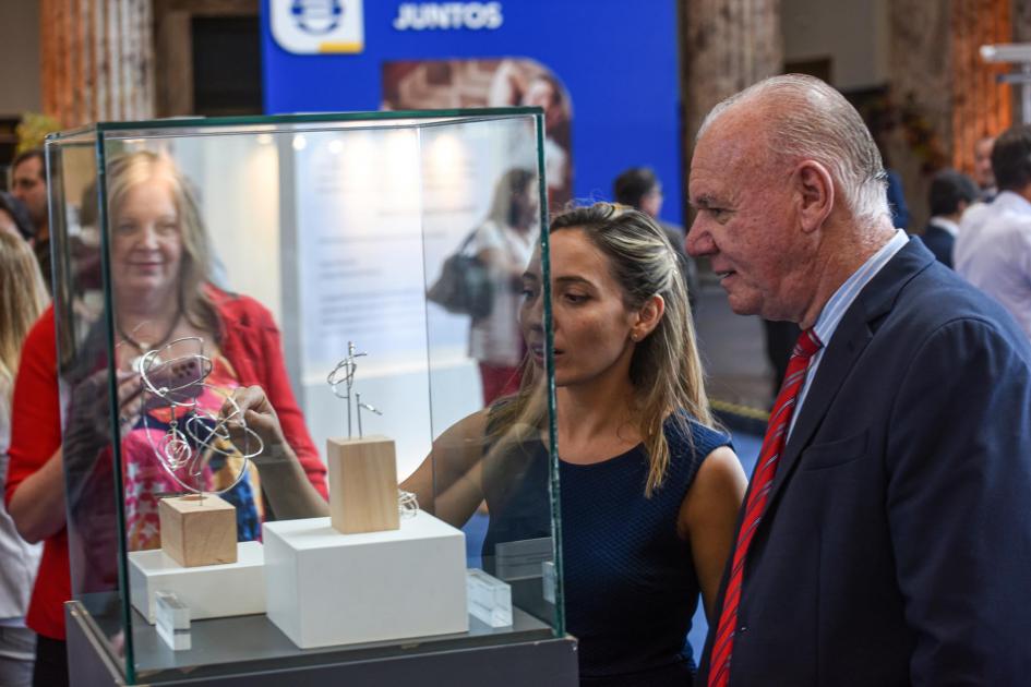 Verri observa un premio en su caja de cristal, junto a una mujer