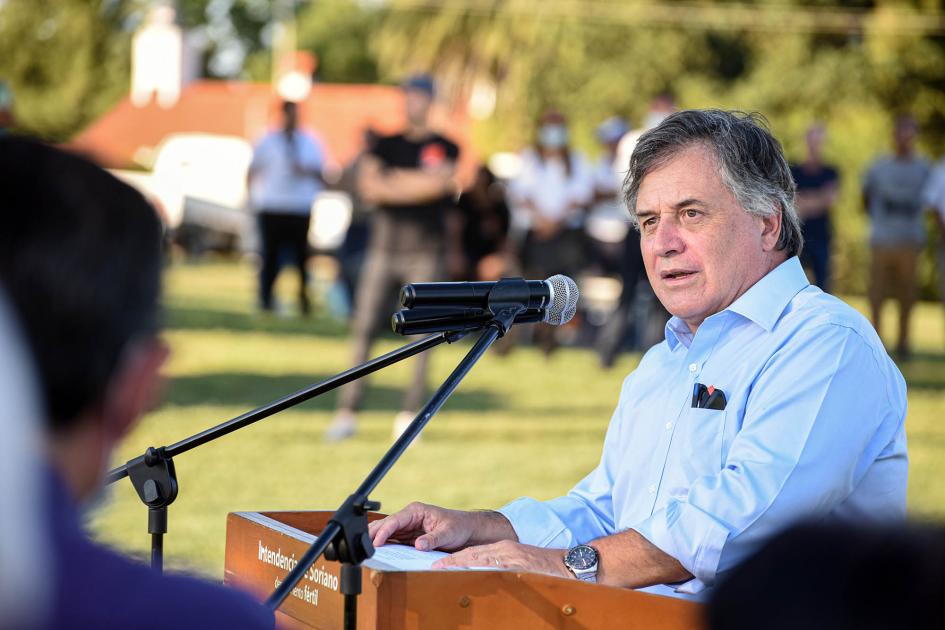 Ministro Omar Paganini habla desde un atril con un micrófono; están al aire libre