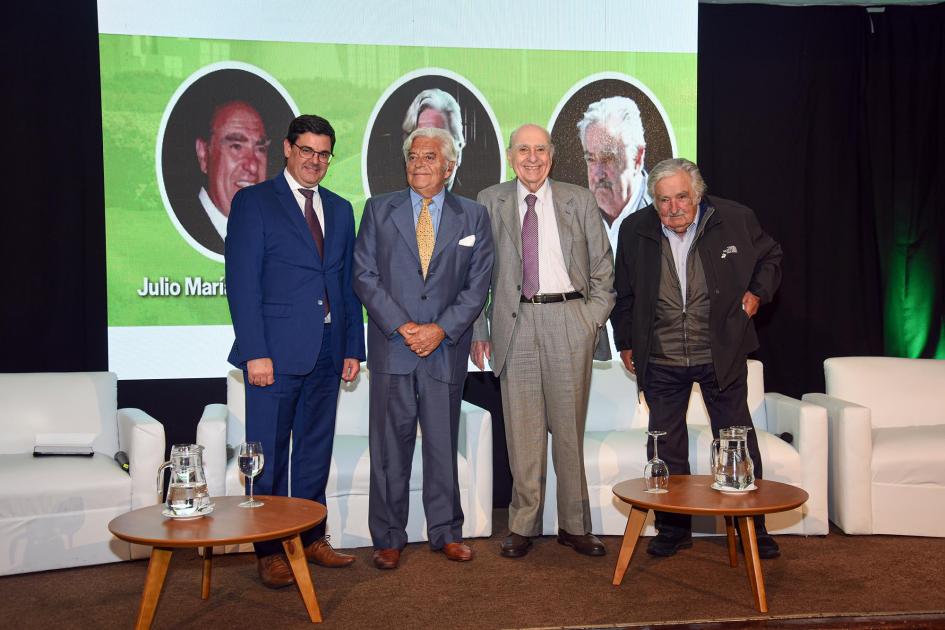 Final del panel de expresidentes De pie: Cantero, Lacalle Herrera, Sanguinetti y Mujica; detrás, una pantalla con sus rostros