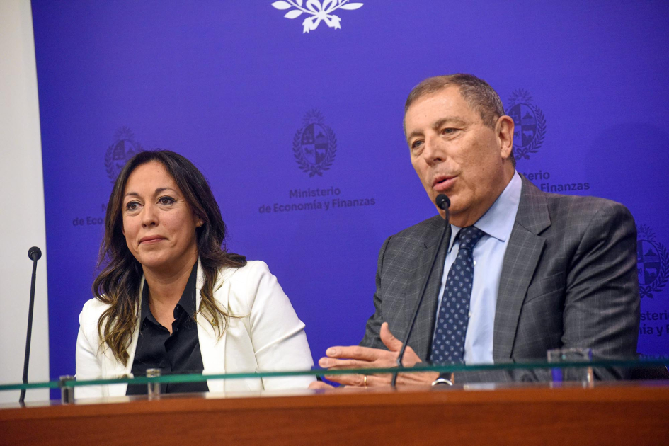 Fernanda Cardona y Gabriel Oddone Ministra Cardona y ministro Oddone sentados. Al fondo back azul