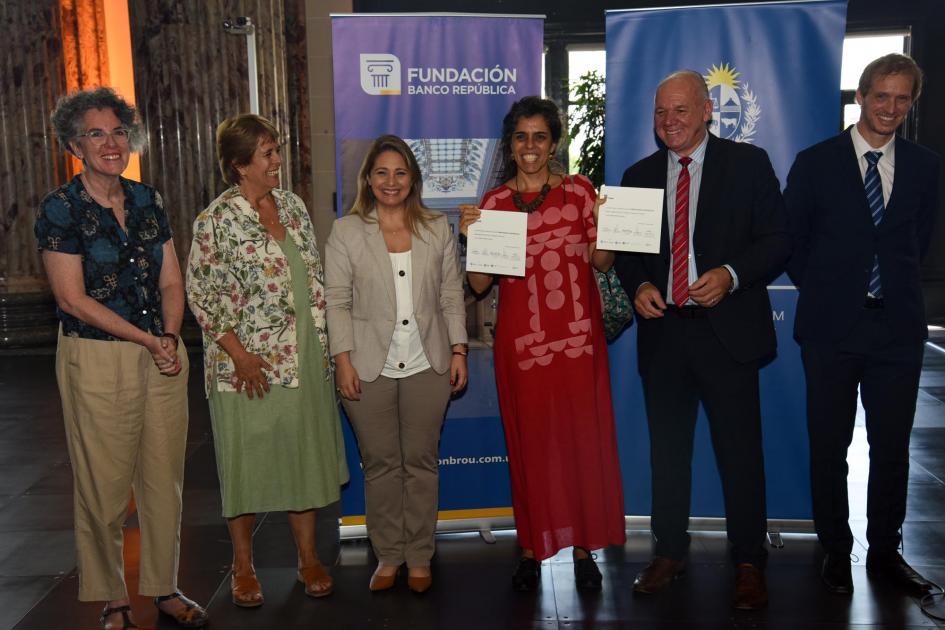 Natalia Cantarelli, con dos diplomas en sus manos, junto a las autoridades