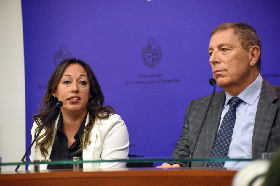 Fernanda Cardona y Gabriel Oddone Ministra Cardona y ministro Oddone sentados. Al fondo back azul