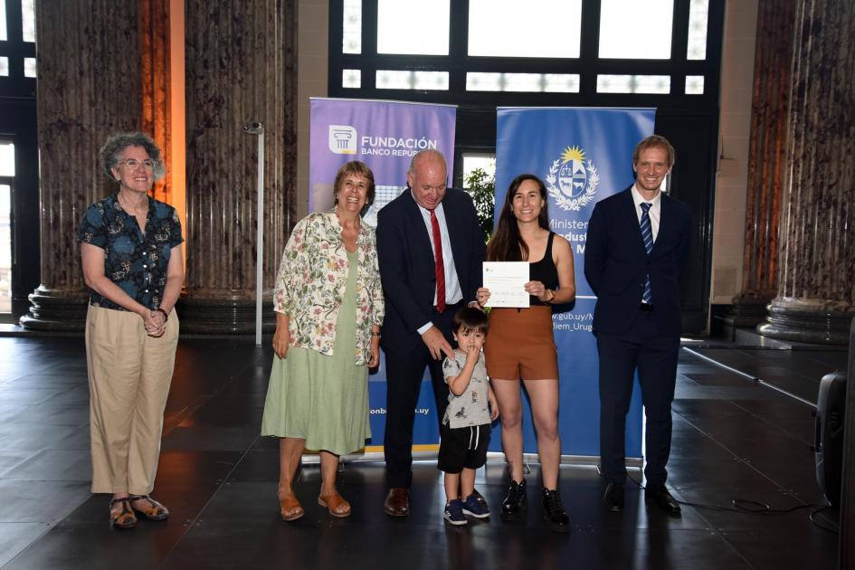 Ganadora del primer premio en categoría Pieza Única, Denisse Arigón Denisse Arigón, diploma en mano y junto a un niño, posa junto a las autoridades