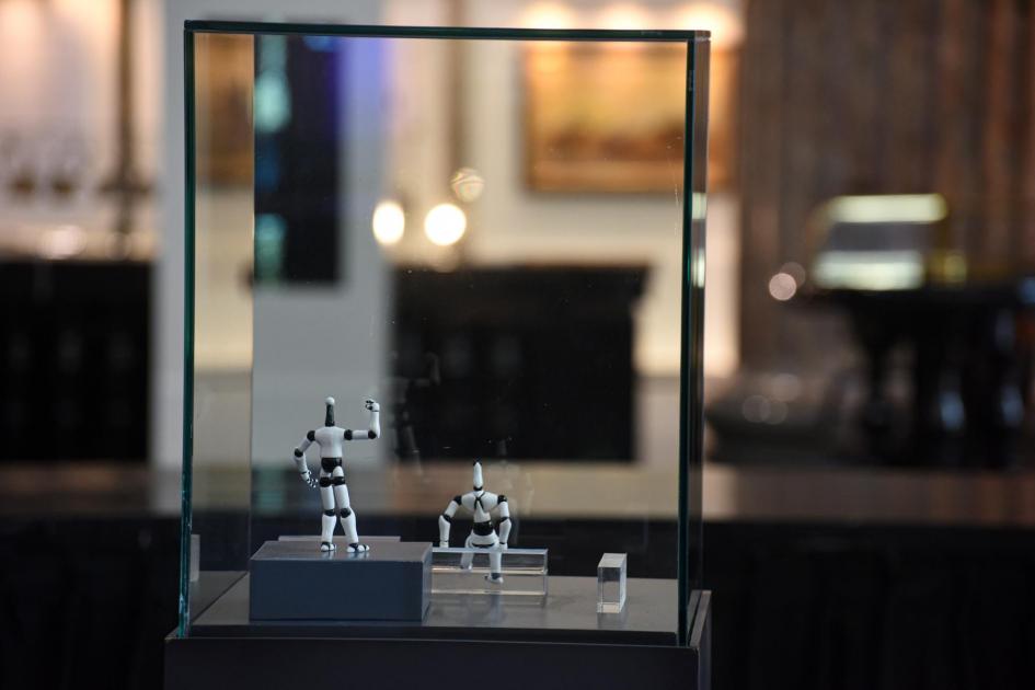 Pieza premiada en la edición 2022 Dos figuras humanoides en blanco y negro, en caja de cristal