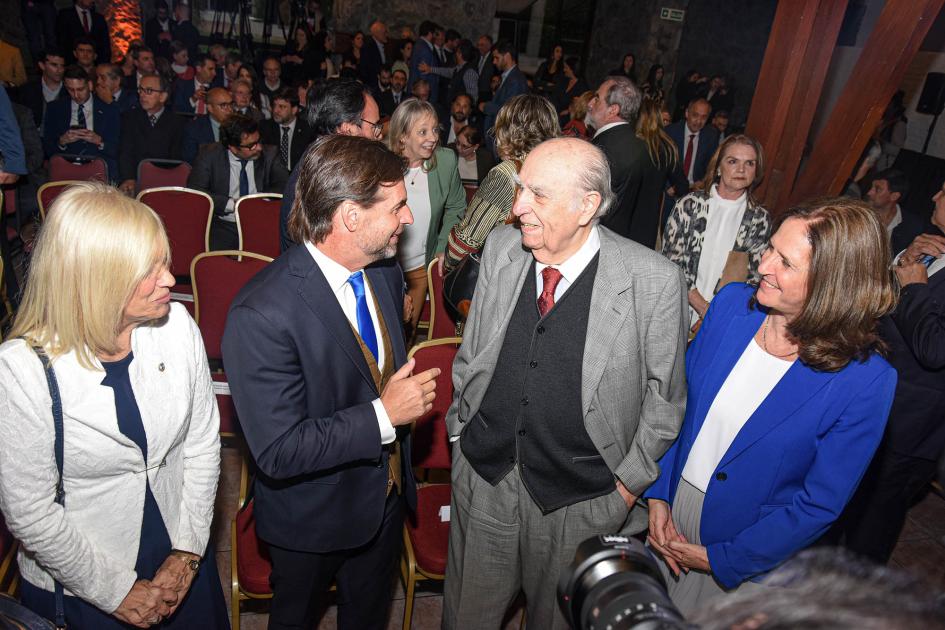 Presidente L. Lacalle Pou, vicepresidenta B. Argimón, ministra E. Facio y expresidente J.Sanguinetti Lacalle Pou, Argimón, Facio y Sanguinetti dialogan; detrás se ve el público