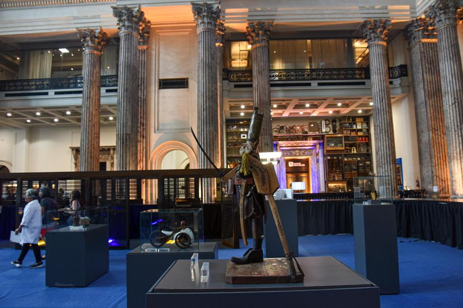 Foto de la exposición, con columnas al fondo; en plano central hay un viejo soldado