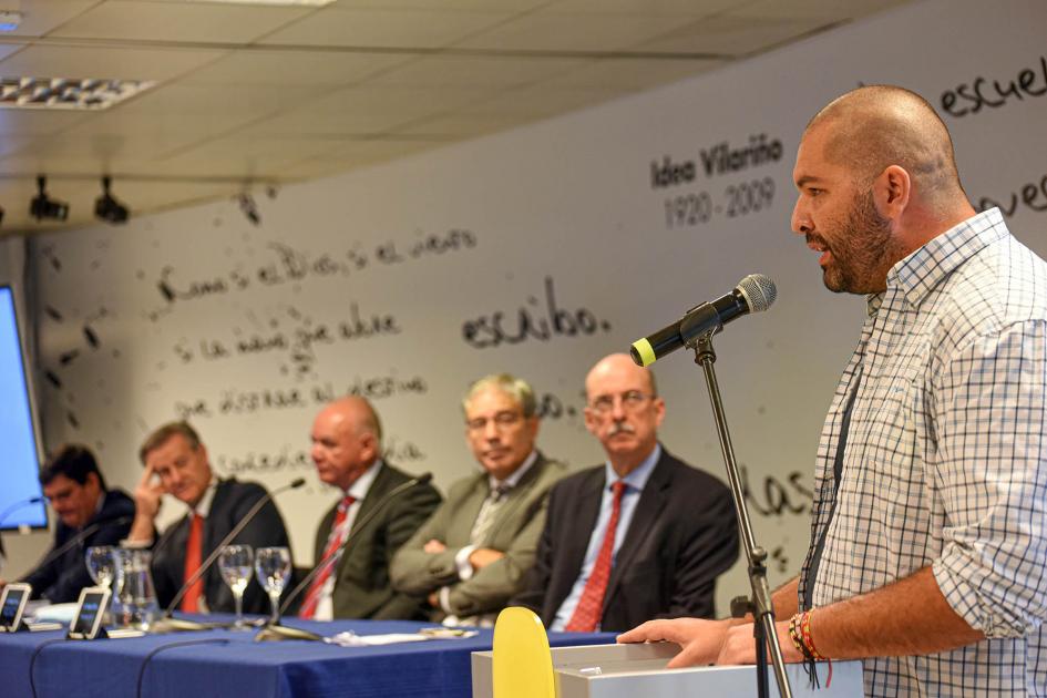 Profesor Valentín Martínez, de la UTU de Colón Habla de pie el profesor Valentín Martínez, observado por la mesa de autoridades