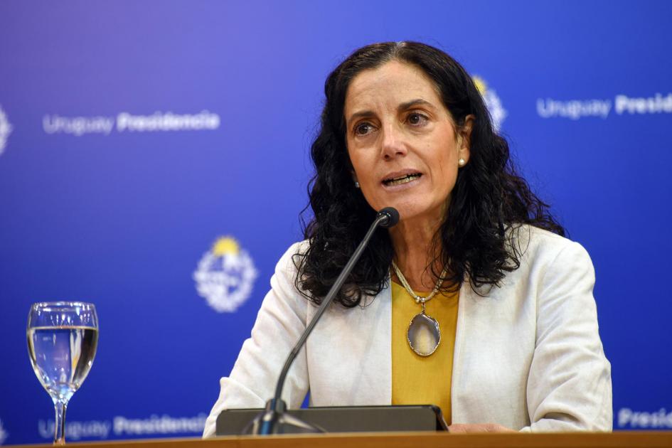 Ministra Azucena Arbeleche; detrás, banner azul de Presidencia