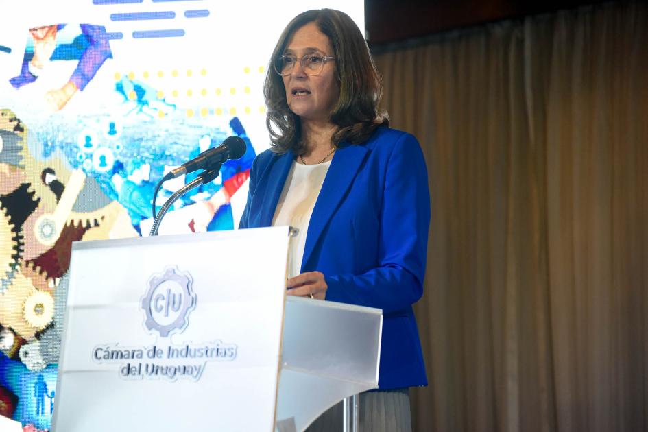 Ministra Facio habla desde un atril con el logo de la CIU